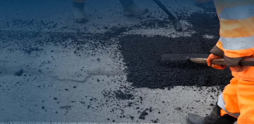 Pro-Pave crew performing pothole repair with fresh asphalt on damaged pavement