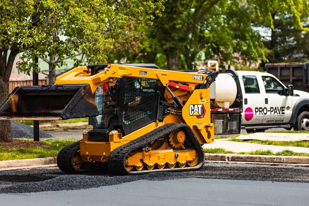Pro-Pave Inc. Contractor Operating a Caterpillar Asphalt Machine