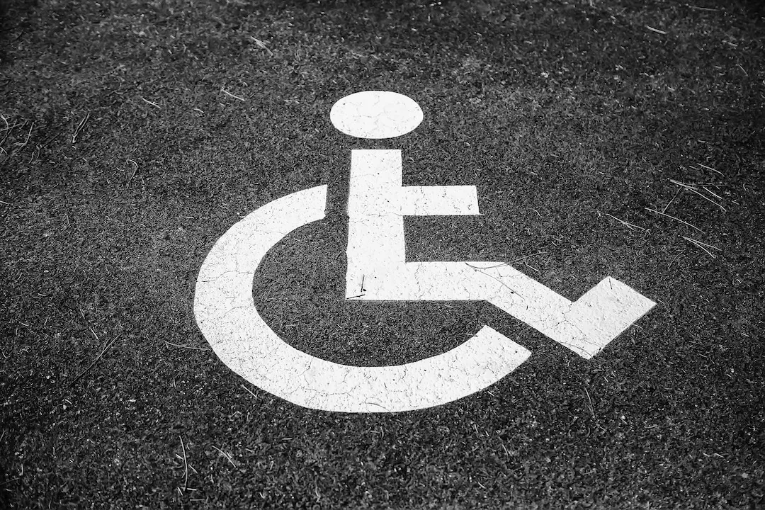 Disabled sign painted on asphalt in parking lot
