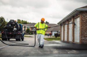 Pro-Pave employee performs Routine Sealcoating