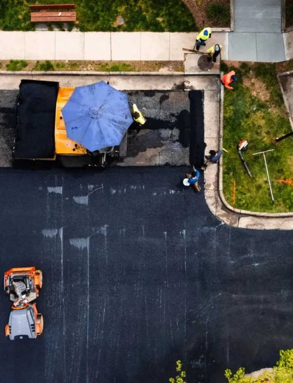 Aerial view of Pro-Pave Inc crew completing asphalt paving on a parking lot with fresh pavement installation